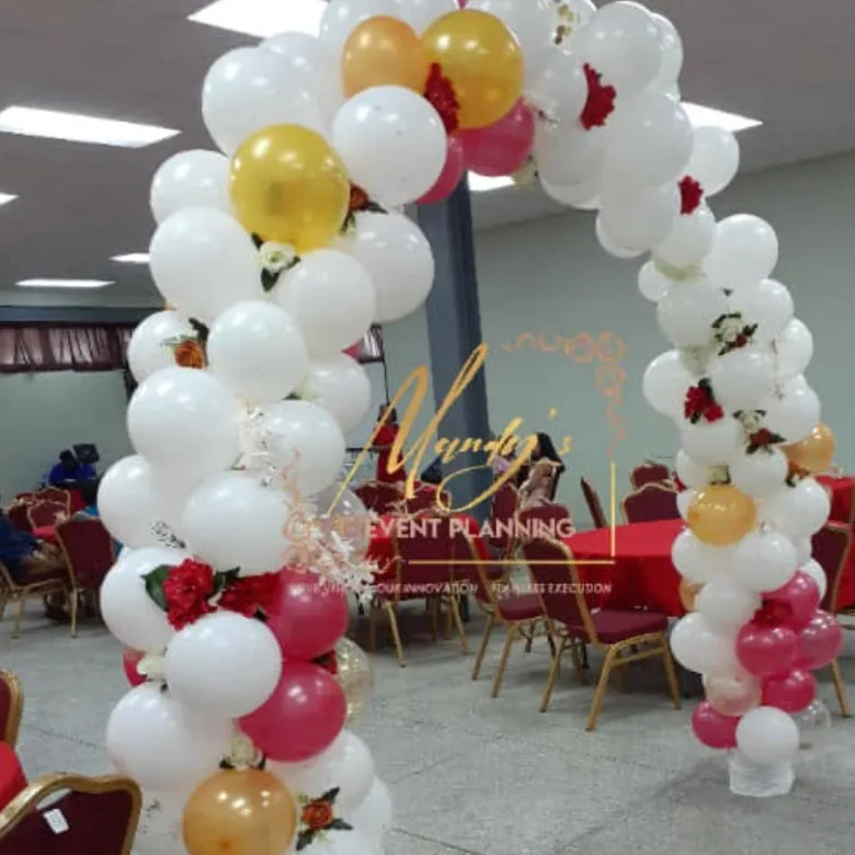 White, gold and red balloon arch at a reception hall